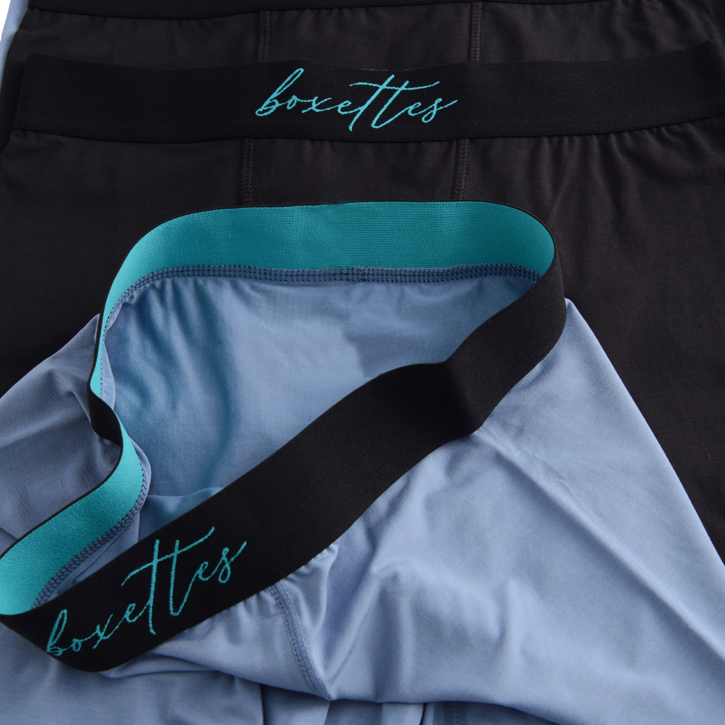 Close-up of black underwear with 'boxettes' branding on a light blue garment.