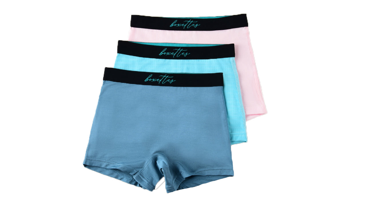 Three girls boxer briefs in blue pink and aqua showing soft modal fabric and comfort waist