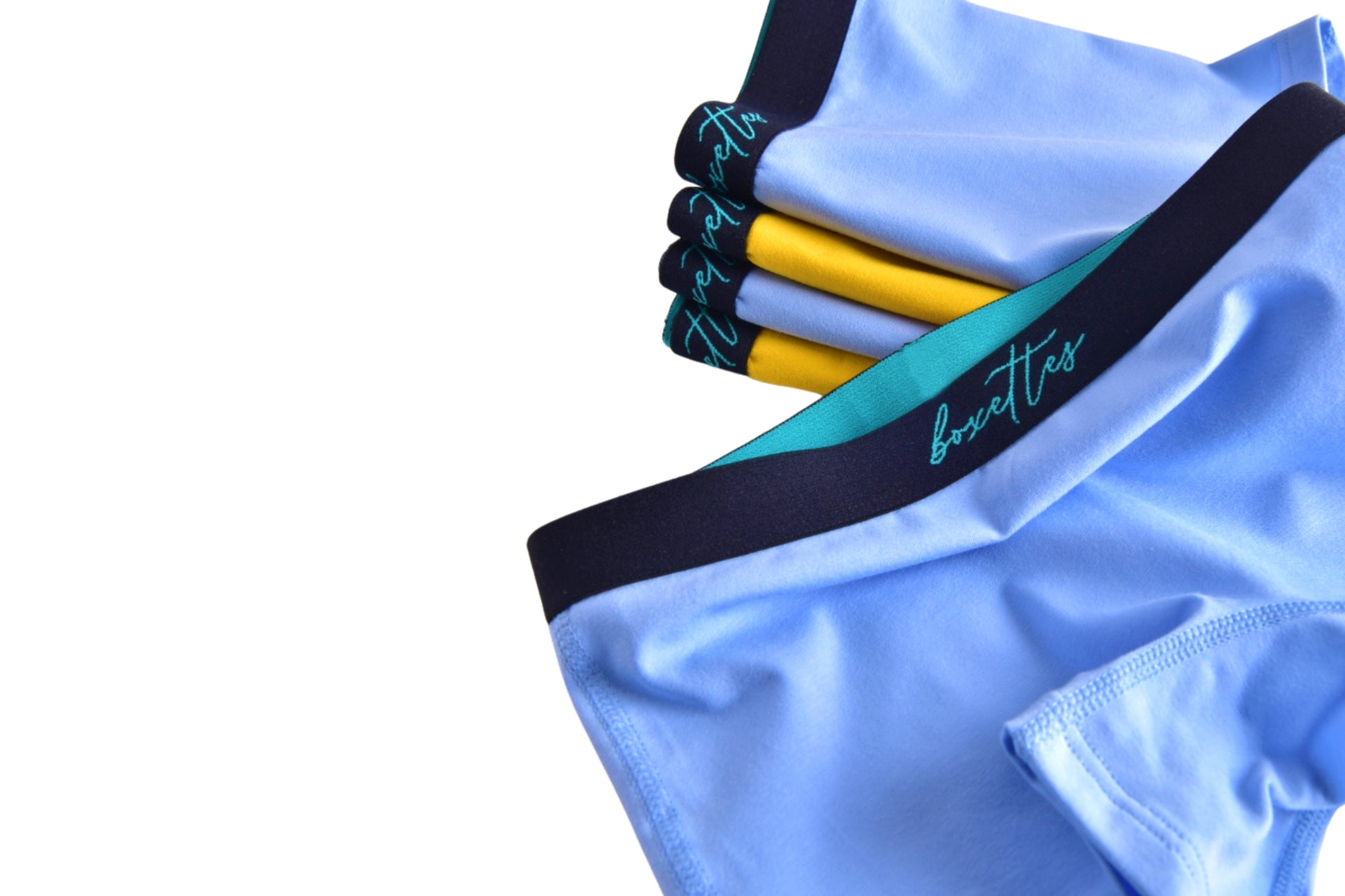 Close up of girls blue modal boxer briefs with yellow and blue pack behind by Boxettes