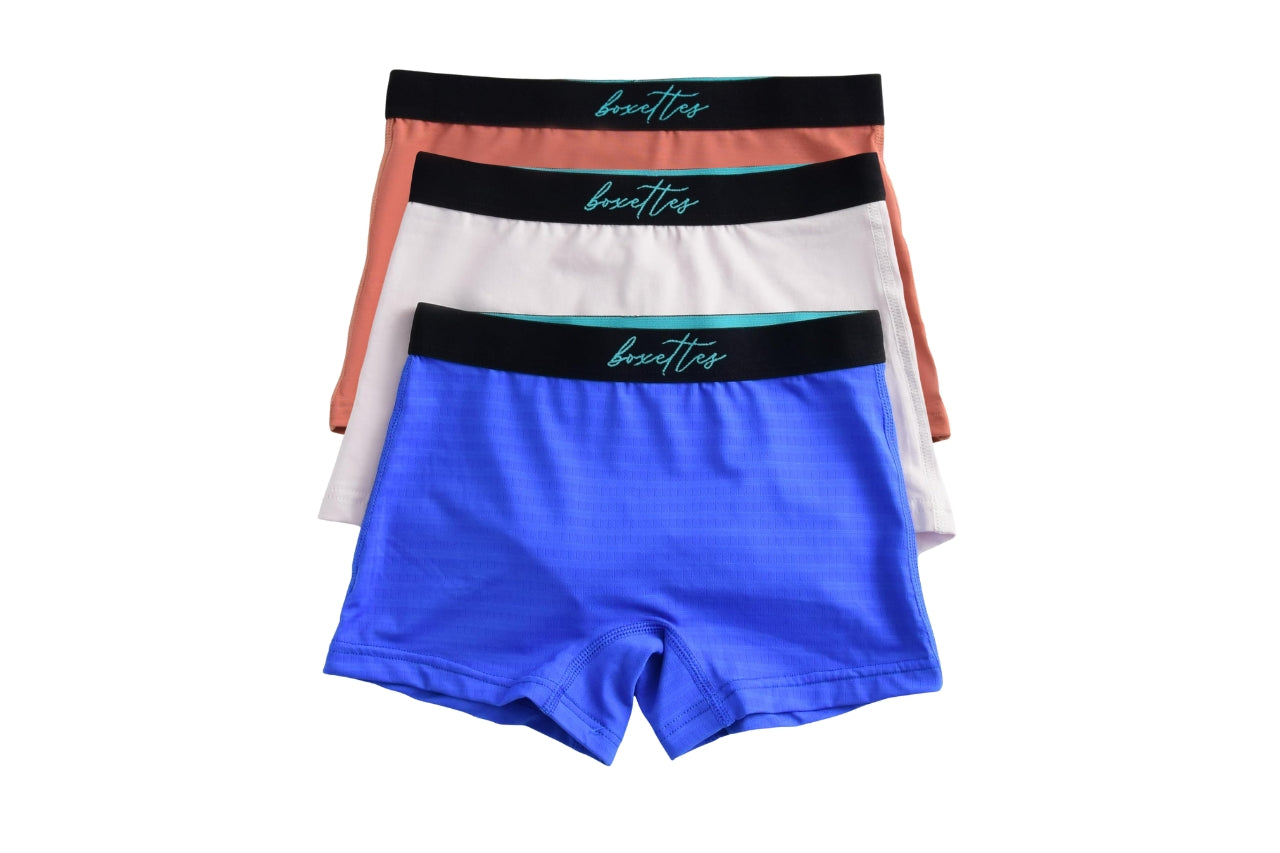 Three pairs of boxer briefs with colorful waistbands on a white background