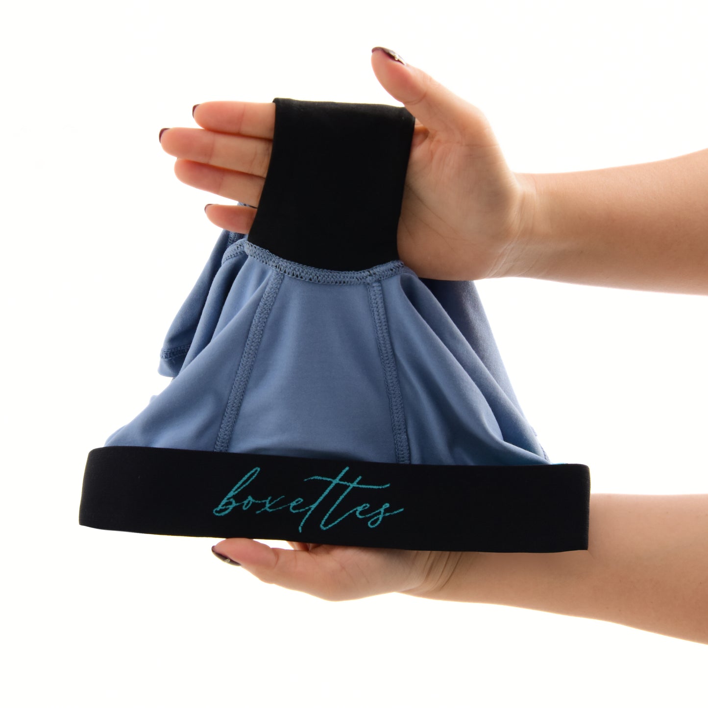 Black headband with 'boxettes' branding held by a person against a white background